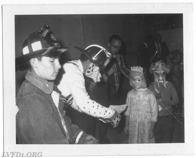 1970:  Kenny Scully assist Tom &quot;Sparky&quot; Mattingly at Halloween Party with fire prevention material